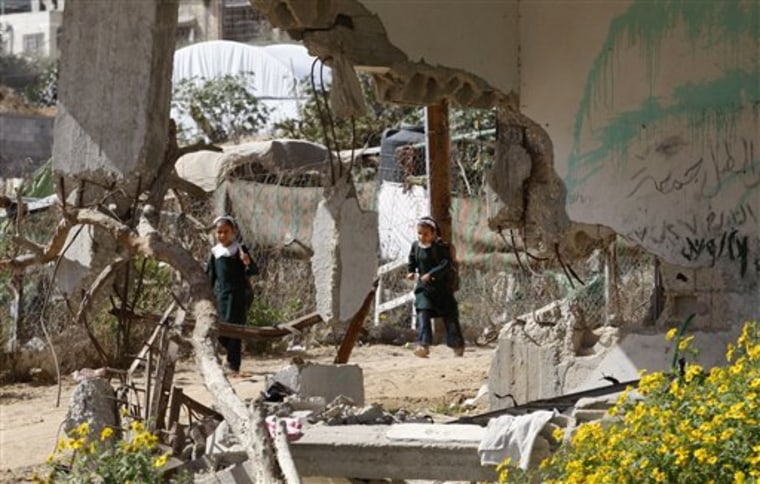 Palestinian girls walk past a house, destroyed in Israel's 2008 Gaza offensive, in Beit Lahiya, in the northern Gaza Strip, on Monday.